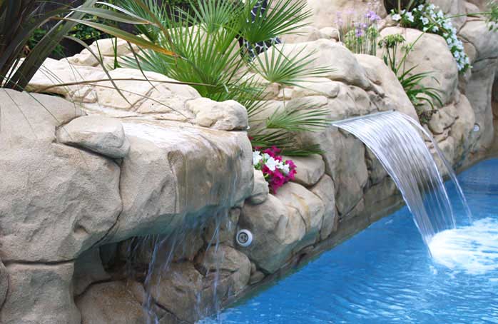 Piscina de obra con rocas y fuente